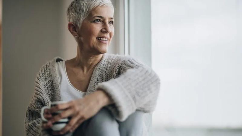 middle age woman sitting near window