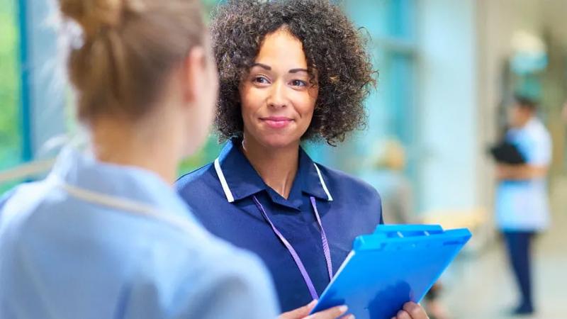 Woman in a hospital holding a clipboard