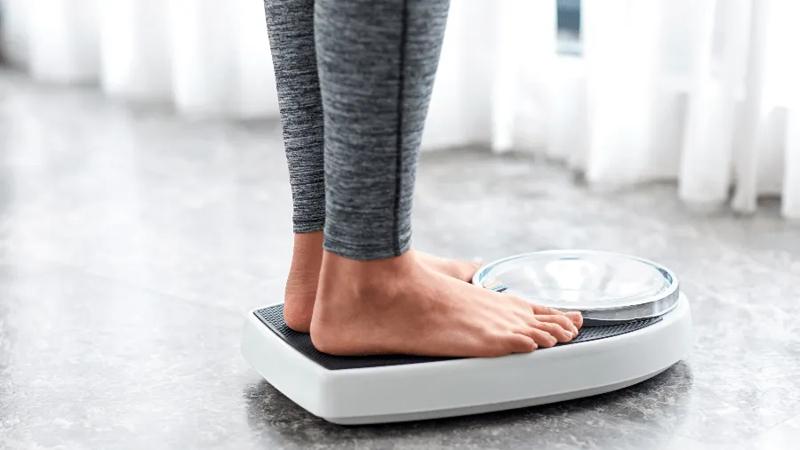 Woman weighing herself.