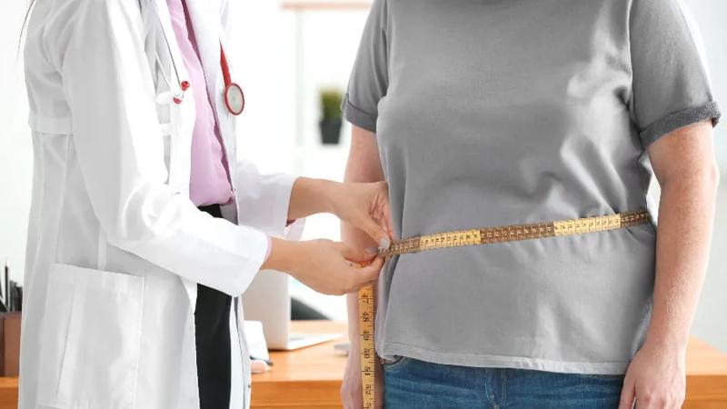 Doctor measuring the waste of a patient