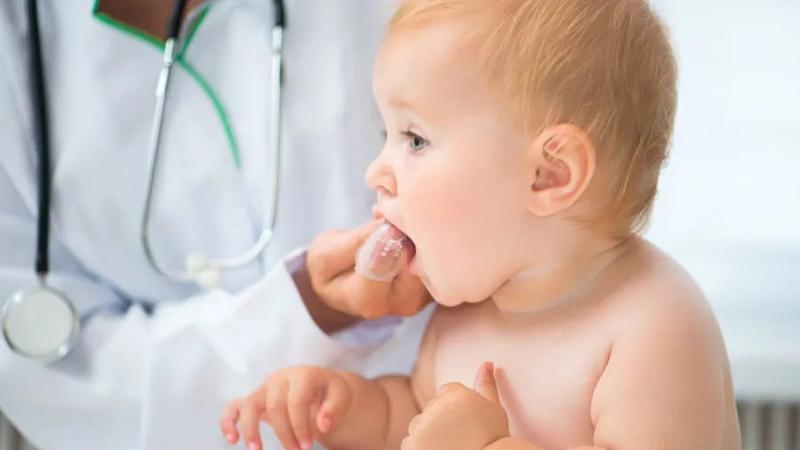 Doctor massaging babys gums