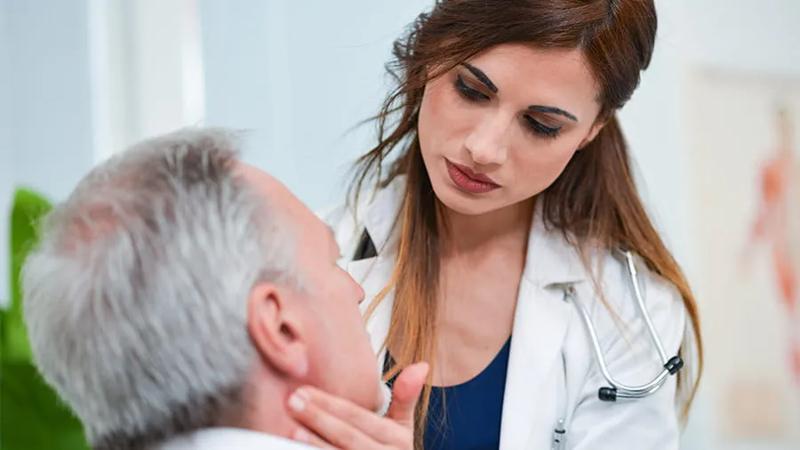 Man getting neck checked by doctor