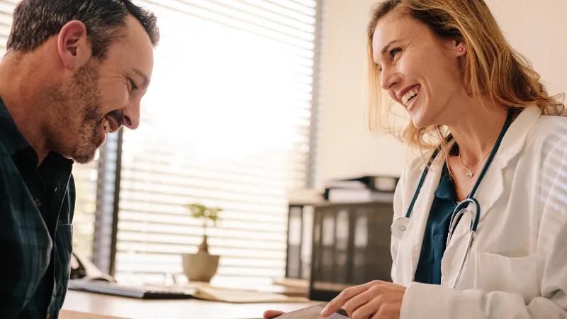 female doctor showing male patient something on tablet