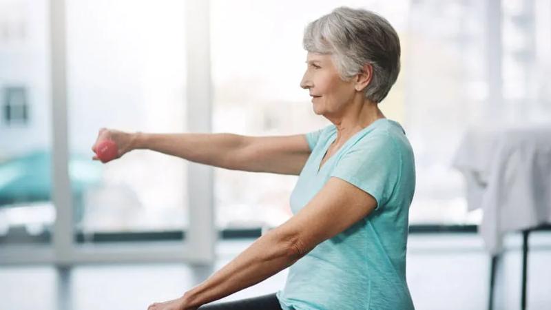 Elderly woman lifting small weights