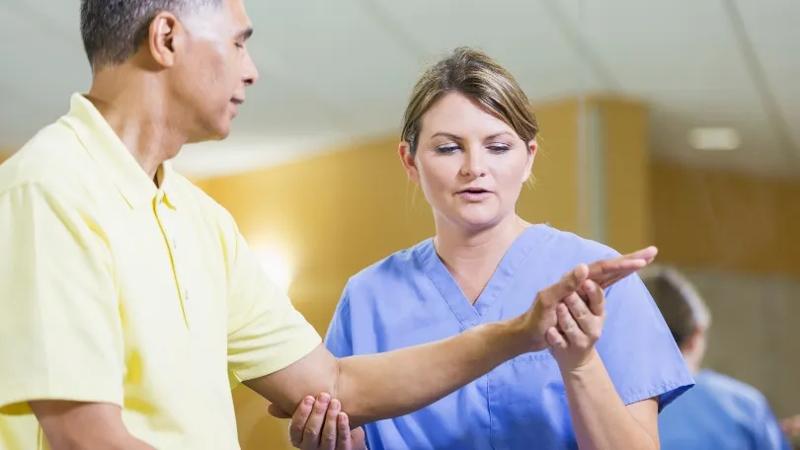 Physical therapist examining a patients elbow
