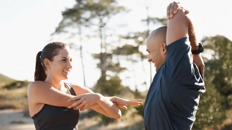 Friends stretching together after an outdoor workout.