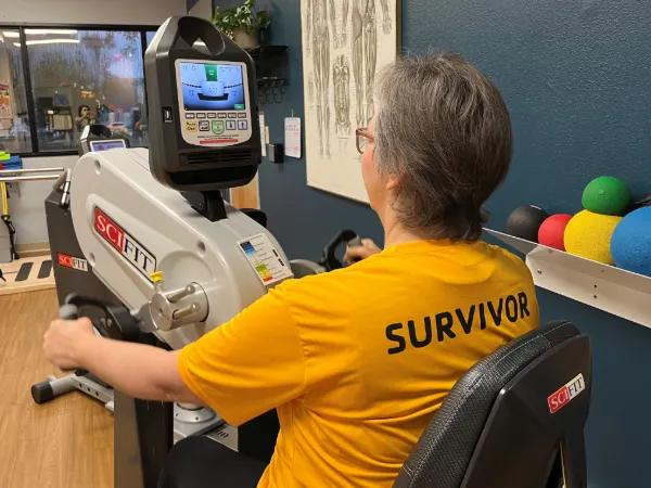 Rear view of lady working out with hand bicycle machine