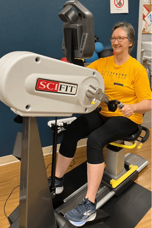 Rear view of lady working out with hand bicycle machine