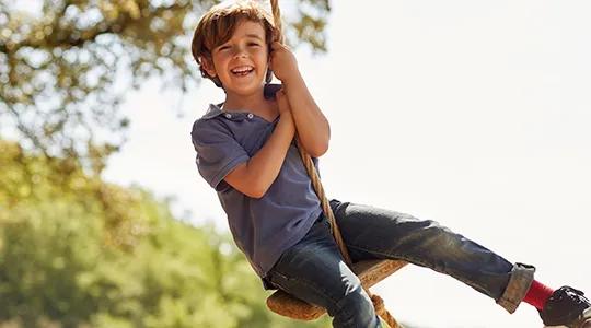 boy swinging on tree tire