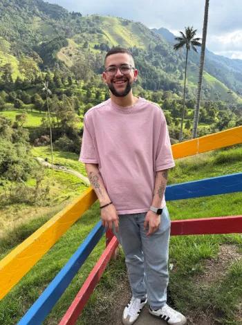 Man smiling in front of a beautiful mountain view
